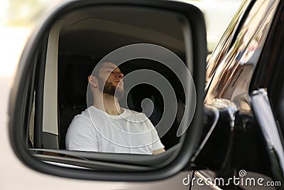 Tired man sleeping in auto, view through car side mirror Stock Photo