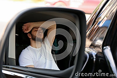Tired man sleeping in auto, view through car side mirror Stock Photo