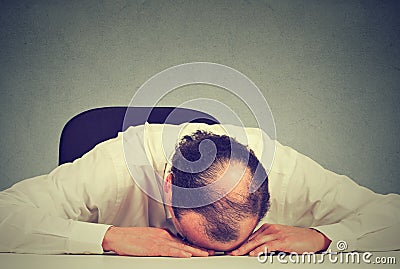 Tired middle aged bald boss company employee sleeping after long working hours Stock Photo