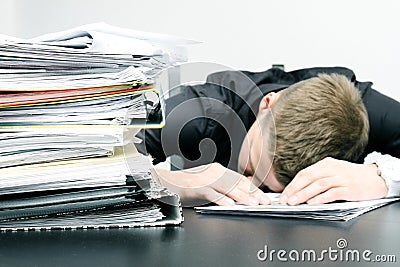 Tired office worker and a pile of documents Stock Photo