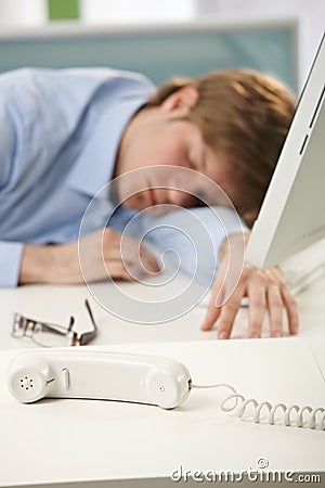 Tired office worker sleeping at desk Stock Photo