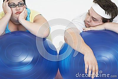 Tired Overweight Couple Resting On Exercise Balls Stock Photo