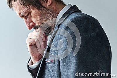 Tired pensive businessman overburdened with thoughts contemplating with hand on chin Stock Photo