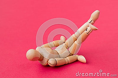 Tired powerless wooden man fallen on the red background Stock Photo