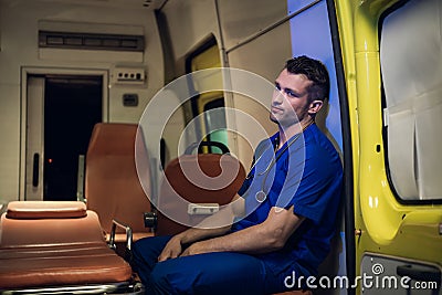 Tired and sad corpsman sits inside the ambulance car Stock Photo