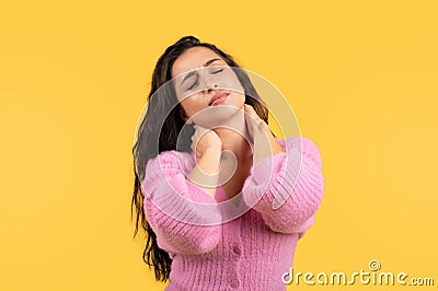 Tired sad millennial middle eastern lady with closed eyes suffering from pain in neck and musculature Stock Photo
