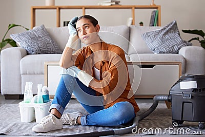 Tired, sad and woman cleaning home overwhelmed, stressed and moody thinking of tasks. Spring cleaning fatigue of young Stock Photo