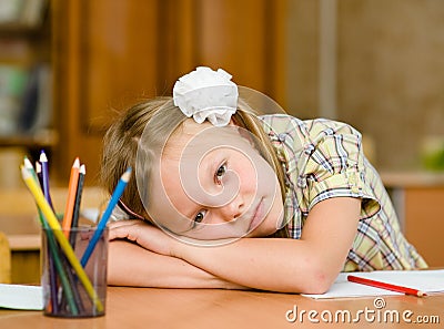 Tired schoolgirl in classroom Stock Photo