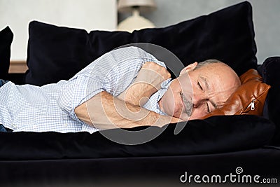 Tired senior hispanic man sleeping on couch, taking afternoon nap Stock Photo