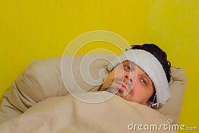 Sick tired man waking up with fever, sars, cold, coronavirus, portrait closeup. Stock Photo