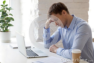 Tired sleepy businessman sitting with closed eyes at workplace Stock Photo