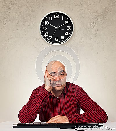 Tired sleepy man with computer keybaord Stock Photo