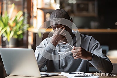 Tired stressed black guy take off glasses feel eye strain Stock Photo