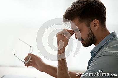 Tired stressed guy taking off glasses feeling eyestrain or headache Stock Photo
