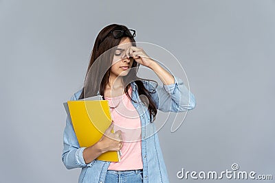Tired indian woman student feel eye strain glasses isolated on grey background Stock Photo