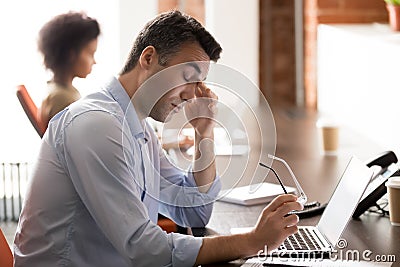Tired stressed middle-aged businessman holding glasses feel eyestrain at work Stock Photo