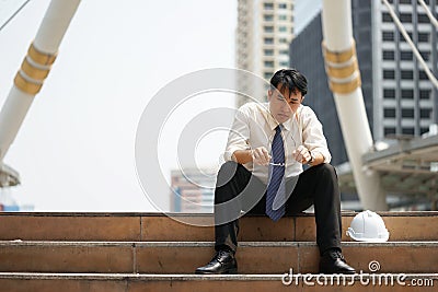 Tired or stressful businessman sit on the stairs after working Stock Photo