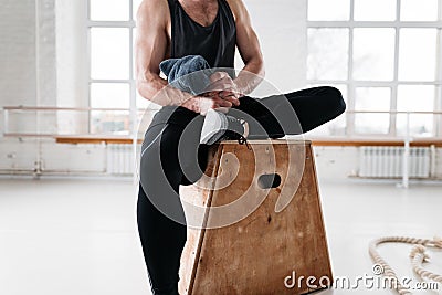 Tired strong man sitting on box at gym Stock Photo