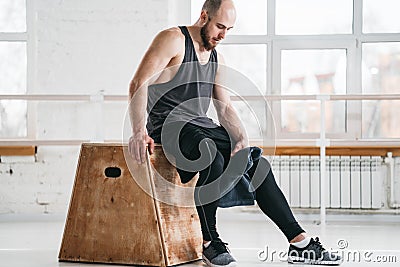 Perspiring fit sportsman resting after hard crossfit workout in light hall Stock Photo