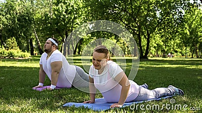 Tired but strong-willed fat people force themselves to do fat-burning routine Stock Photo