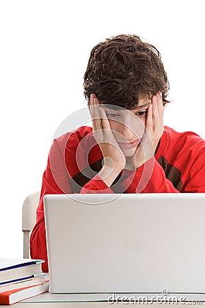 Tired teenage boy using laptop Stock Photo