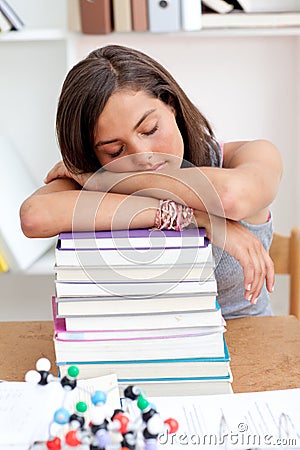 Tired teenager sleeping in a library Stock Photo