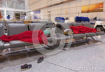 Tired travelers sleeping on the airpot departure gates bench Stock Photo