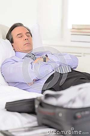 Tired of traveling. Tired mature businessman sleeping on the sofa at home Stock Photo