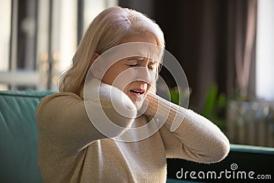 Tired upset old senior woman feeling stiff neck pain concept Stock Photo