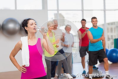 Tired woman drinking water at gym Stock Photo