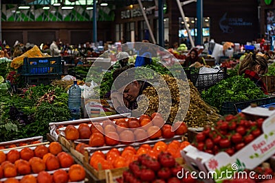 Tired woman fruit seller is sleeping on the fruit market counter. YasÄ±l Bazar Green Market Editorial Stock Photo