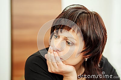 Tired woman holding head, looking out Stock Photo