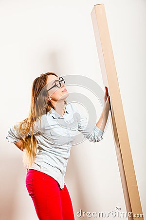 Tired woman moving into apartment carrying box. Stock Photo