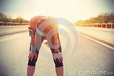 Tired woman runner taking a rest after running hard Stock Photo