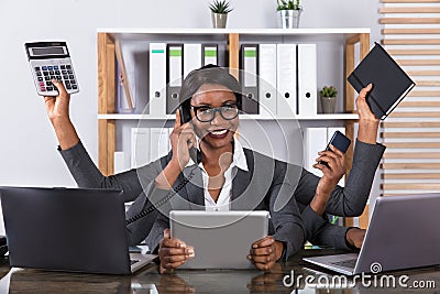 Tired Woman Doing Multitasking Work On Laptop Stock Photo