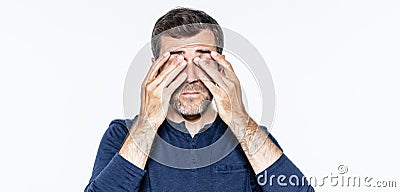 Tired young bearded man massaging his sleeping eyes from burnout Stock Photo