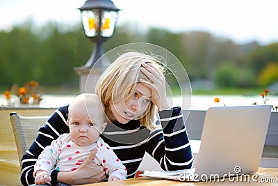Tired young mother working oh her laptop Stock Photo