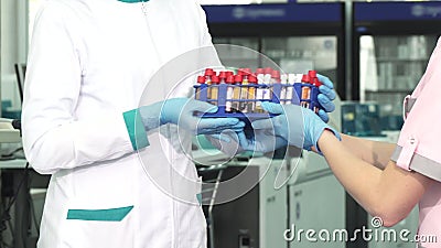 Tiro colhido de um trabalhador médico que recebe amostras da análise de sangue de um colega vídeos de arquivo Tiro colhido de um trabalhador médico que recebe amostras da análise de sangue de um colega vídeos de arquivo