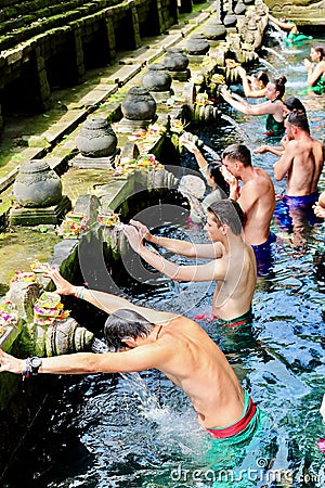 Locals and tourists going for ritual purification in the holy spring waters of this temple founded around a large water spring. Editorial Stock Photo