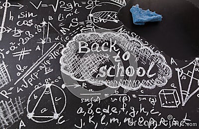 Title Back to school, formulas written by white chalk on the black school chalkboard and blue rag for erasing Stock Photo