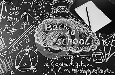 Title Back to school, formulas written by white chalk on the black school chalkboard and notebook with pencil Stock Photo