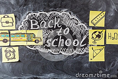 Title Back to school written by chalk on the black chalkboard and the school bus drawn on the pieces of paper Stock Photo