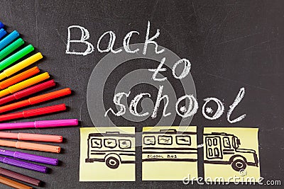 Title Back to school written by chalk and image of the school bus drawn on the pieces of paper on the chalkboard Stock Photo