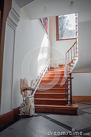 Tlatelolco, CDMX, 10 12 22, Antique stair lift with folding seat, luxurious circular wooden staircase Editorial Stock Photo