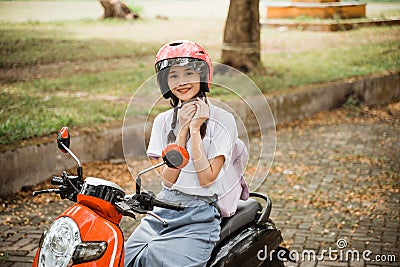 To be safe the student girl tightens the helmet strap Stock Photo