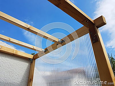 to build a greenhouse diy at the house facade. double-walled panels and squared timber Stock Photo