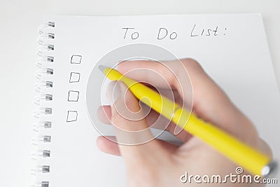 To Do list with empty checklist and women hand with yellow pen. Paper spiral notebook Stock Photo