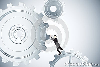 To make business work concept with businessman spinning gears Stock Photo