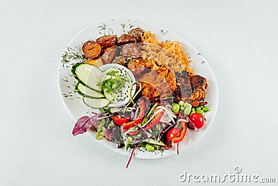 To view closeup of roasted orange bell peppers, onion, radish, lemon and lettuce in a black bowl Stock Photo