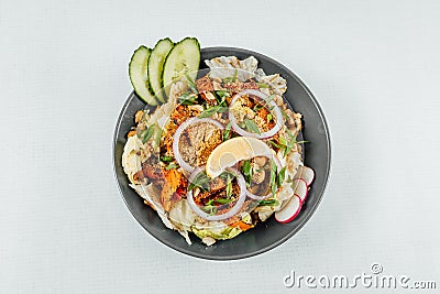 To view closeup of roasted orange bell peppers, onion, radish, lemon and lettuce in a black bowl Stock Photo